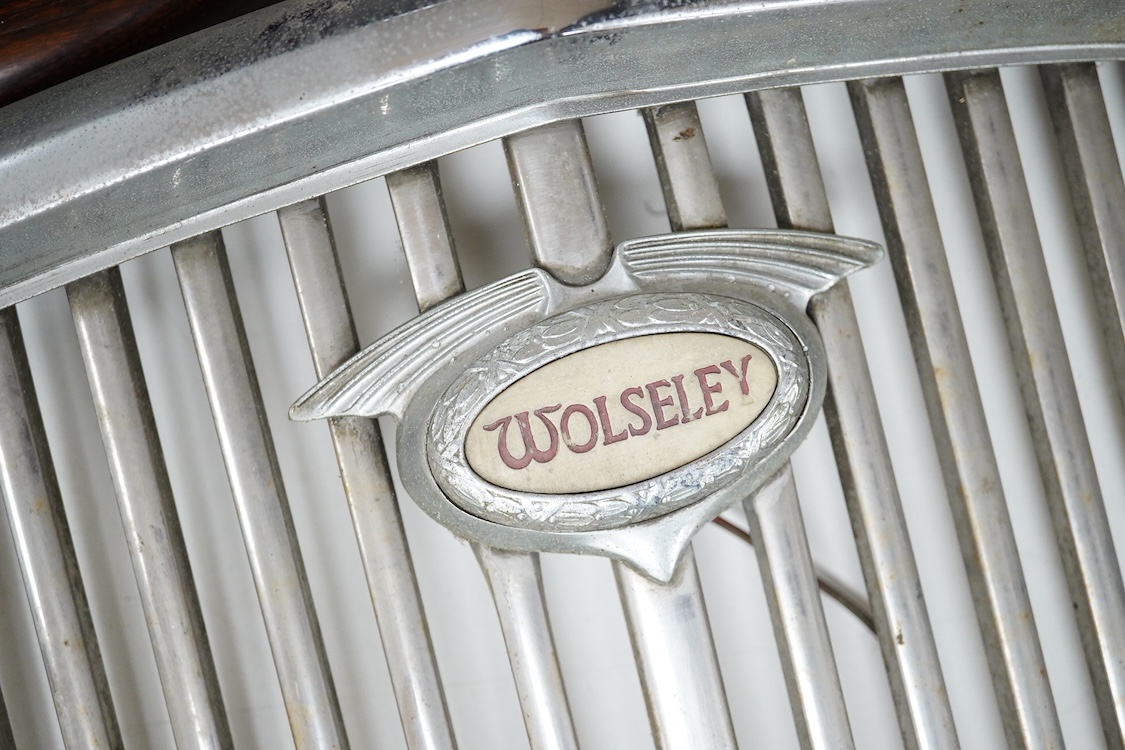 A 1950s Wolseley automobile radiator grill, with a lit logo to the centre of the grill, 40cm x 43cm